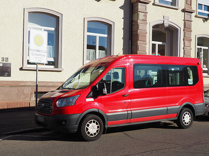 roter Schulbus parkt vor dem Gebäude des Helen-Keller Schulkindergarten